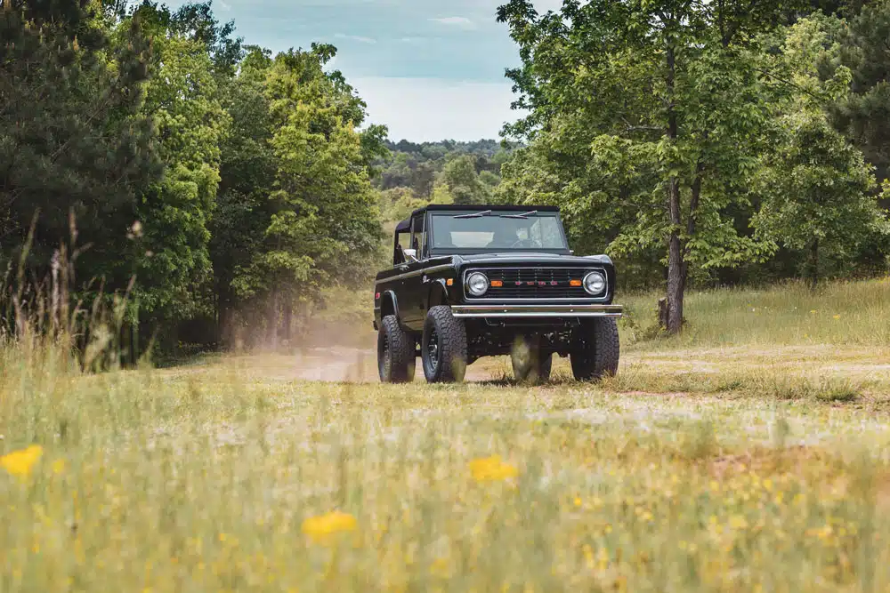 Vintage Bronco in all black driving on county road in Tennessee
