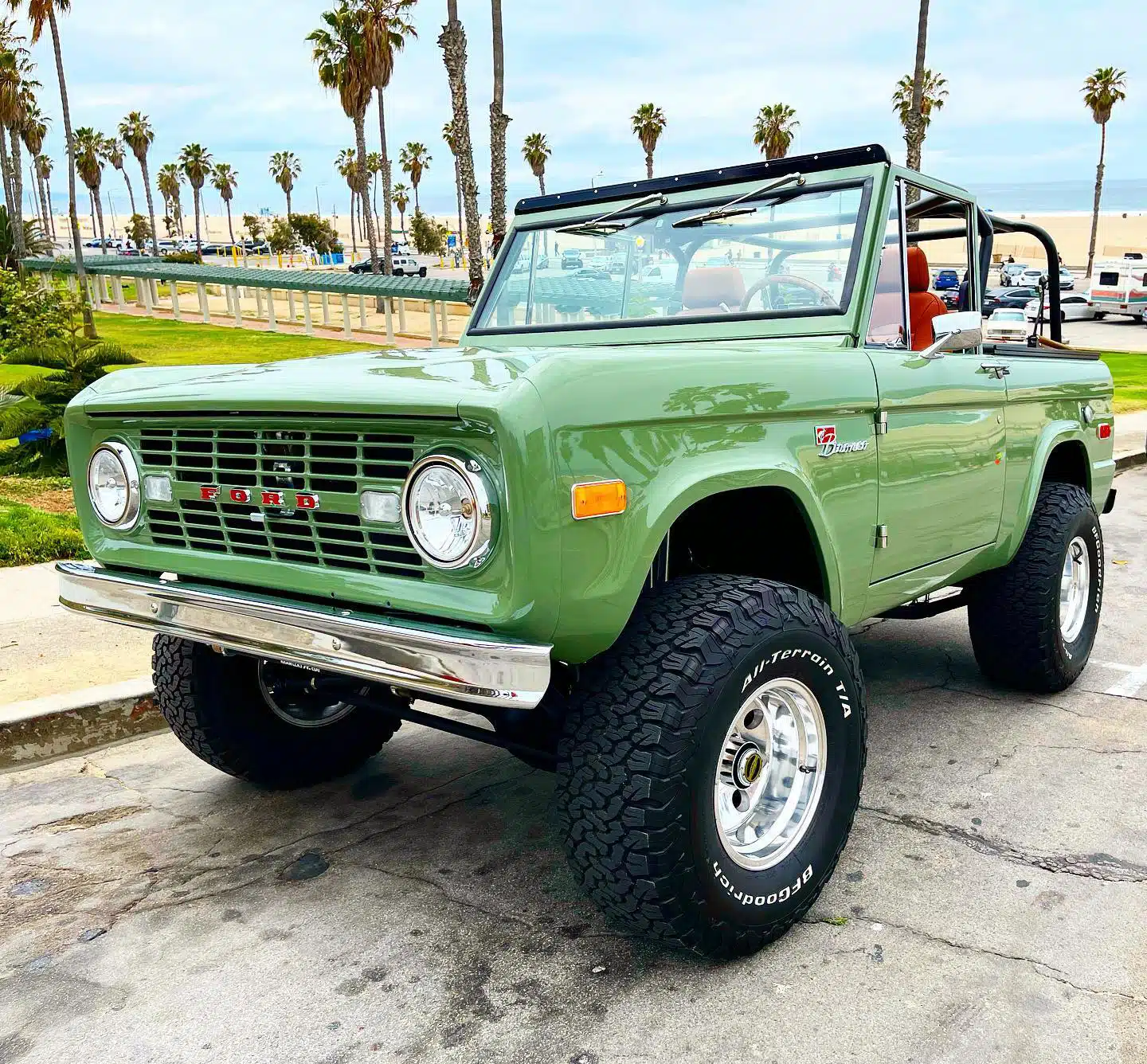 A classic first generation Ford Bronco parked by the beach