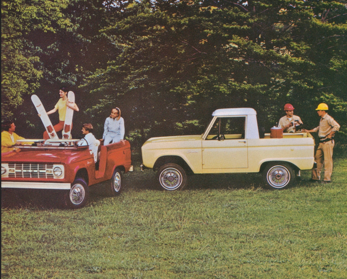 Yellow and white Bronco roadster with people enjoying outdoor activities in a park-like setting